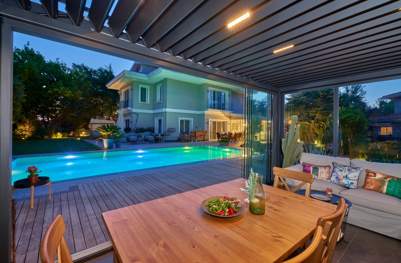 A 30-foot Konig sliding glass door system installed in a custom Texas home, late afternoon golden hour light grazing across matte black aluminum frames.